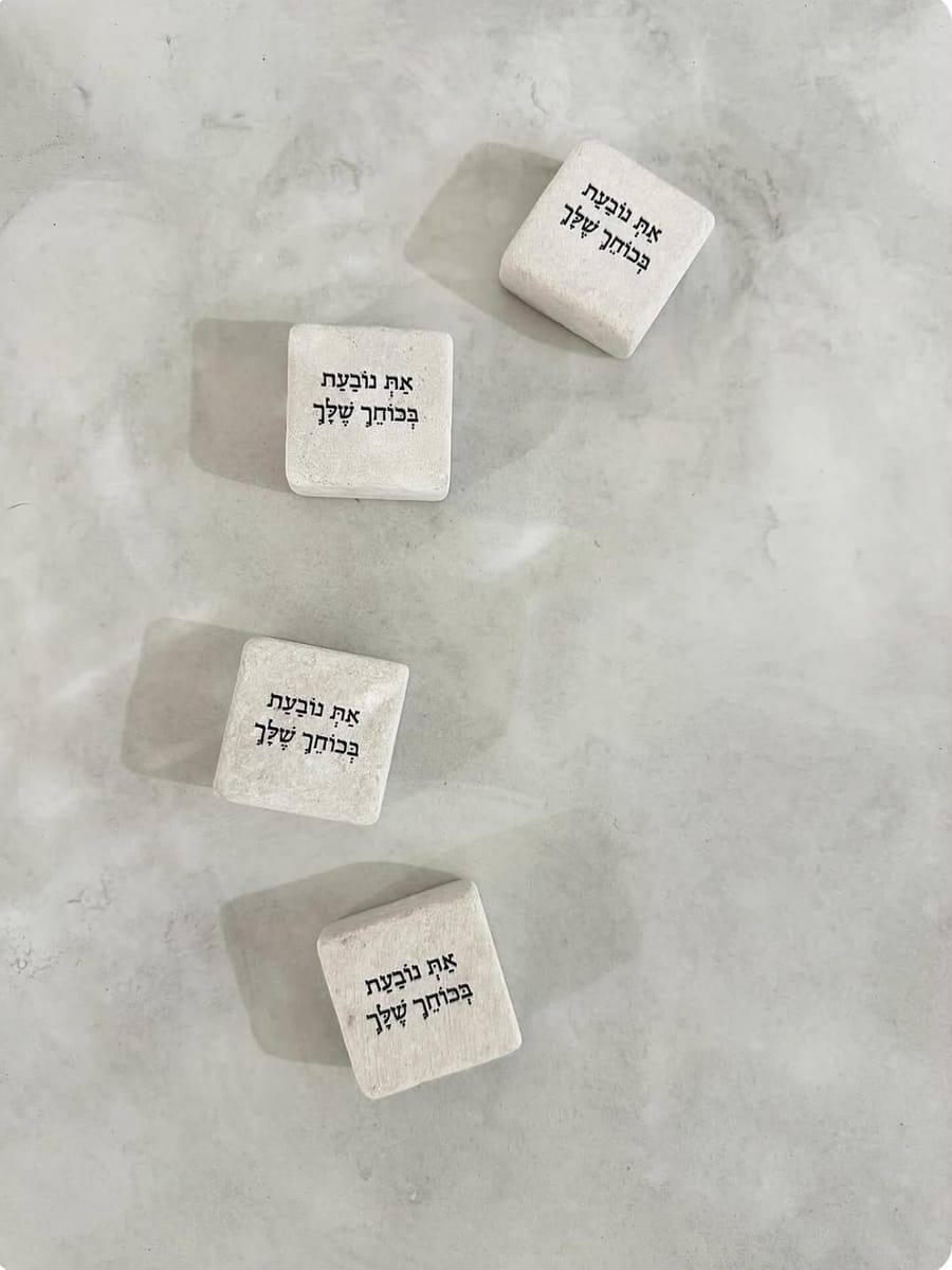 אבני הנביעה עם המשפט 'את נובעת בכוחך שלך'